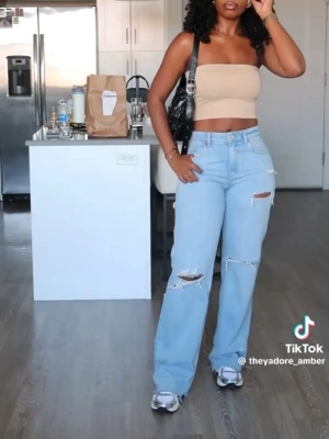 Ljusa baggy ripped jeans - Säljer ett par ljusblå baggy jeans med flera slitningar och hål på benen. Jeansen har hög midja och raka ben för en avslappnad och trendig look. Perfekta för dig som gillar streetstyle och vill ha en cool vibe i vardagen. Storlek 32 men skulle säga mer 34 då de är stora i storlekarna 