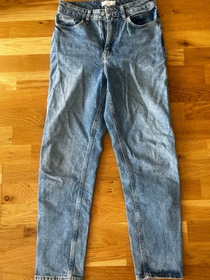 Blå mom jeans från H&M - Säljer ett par klassiska blå mom jeans från H&M med hög midja och raka ben. 