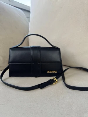 Svart handväska  - Snygg svart handväska från . Väskan har ett stilrent, rektangulärt format och ett elegant handtag upptill. Perfekt accessoar för att lyfta din outfit. Köpt i Spanien, aldrig använts och har bara legat i garderoben 