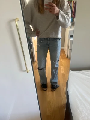 Ljusblå ripped jeans från ZARA populära - Säljer ett par ljusblå jeans från ZARA i storlek 34. Jeansen har raka ben, slitningar över knäna och klassisk femficksmodell. Tillverkade i denim med snygg tvätt och avslappnad passform. Säljer flr att dom är flr små. Kontakta för fler bilder eller prisförslag💕