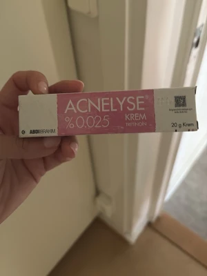 Acnelyse tretinoinkräm 0.025% - Acnelyse kräm med 0.025% tretinoin, perfekt för hudvård och behandling av akne. Tuben innehåller 20 g och kommer i en vit och rosa förpackning. Krämen är enkel att applicera och passar dig som vill ha en effektiv lösning för oren hud.