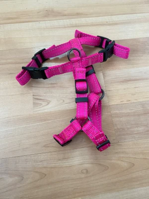 Dogman hundsele rosa XS/S - Säljer en justerbar Dogmansele i storlek XS/S. Selen är oanvänd. Halsmått 26-40cm, bröstmått 38-50cm.Tillverkad i slitstark nylon med svarta plastspännen och metallringar för koppel. Perfekt för promenader med hund. Ställbar vilket passar bra för växande valp exempelvis. 