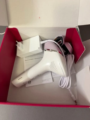 IPL hårborttagningsapparat Philips - Säljer en IPL hårborttagningsapparat från Philips i vitt och ljusrosa med sladd och laddare. Kommer i originalkartong med tillhörande manual. Perfekt för smidig hårborttagning hemma med modern teknik. Köptes från Clas Ohlsson för 6000kr. Helt oanvänd.