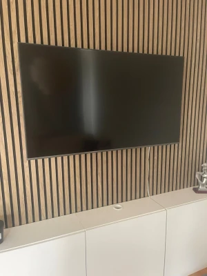 Svart platt-TV från Samsung - Säljer en stilren svart platt TV från Samsung. Skärmen har tunn ram och modern design, perfekt för att hänga på väggen. Passar snyggt in i alla rum och ger en clean look till inredningen. Enkel att koppla in med synliga portar på baksidan.