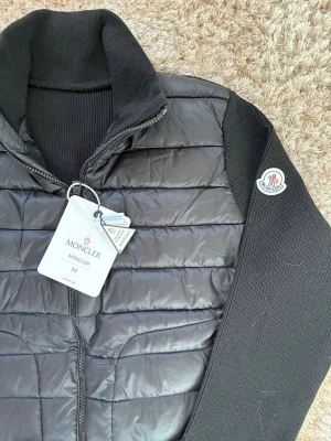 Svart cardiganjacka från Moncler - Riktig snygg stilig moncler cardigan i svart färg , storlek M men passar mycket bra för dig som bär S också! Hör av er vid minsta fundering!😌