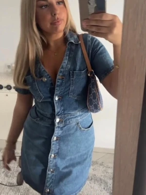 Kort jeansklänning med knappar - Snygg kort jeansklänning med v-ringning från Zara , korta ärmar och knappar hela vägen framtill. 