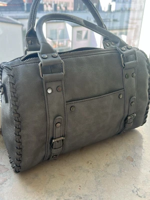 Grå citybag  - Snygg grå handväska som rymmer mycket och har både ett litet fack på utsidan och ett innerfack med dragkedja. Säljer för att jag inte använder den längre. Priset är förhandlingsbart 💕