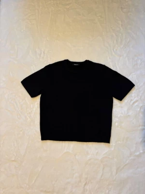 Svart stickad t-shirt - En svart stickad t-shirt från Gina Tricot. Använd 1/2 ggr men blivit för liten. Strl L men passar S/M😊
