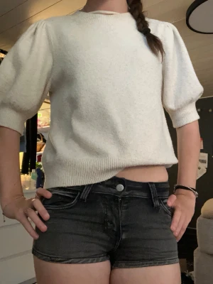 Svarta denimshorts med låg midja - Säljer ett par svarta jeansshorts i stretchigt denimtyg. Shortsen har låg midja, klassiska fem fickor och knappgylf. Snygg tvättad look med slitningar och korta ben.  Perfekta för varma dagar och enkla att matcha med olika toppar, samt med blusar för en fin ”gå på stan” stil ❤️  HELT NYA ALLDRIG ANVÄNDA, bara hängt på en galje hitils