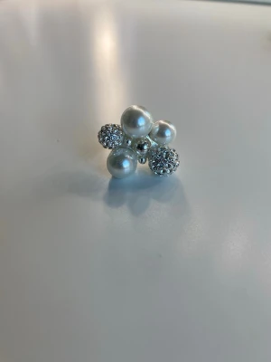 Berry pearl ring från Ioaku - Berry pearl ring från ioaku med vita och glittriga pärlor. De går att justera ringen beroende på vilken storlek man vill ha