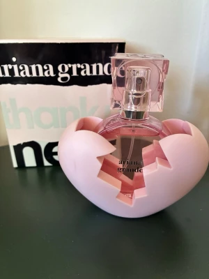 Ariana Grande parfym - En söt parfym från Ariana Grande, Thank U Next 50ml, med en unik hjärtformad flaska i rosa plast och glas. Parfymen är endast testad, missfärgning finns på baksidan av hjärtat