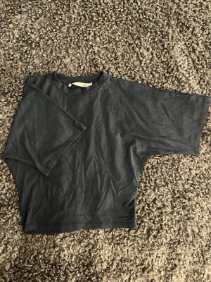 Mörkgrå loose t-shirt - En enkel och stilren mörkgrå t-shirt med loose passform och korta ärmar. Tillverkad i mjuk bomull som känns skön mot huden. Perfekt till jeans eller shorts för en avslappnad look.
