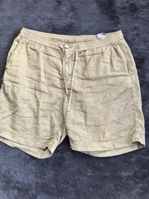 Beige shorts med snörning från Morris  - Snygga beige shorts med snörning i midjan och knappstängning. Två sidofickor fram och två bakfickor med knapp. Perfekta för varma dagar och har en avslappnad passform.