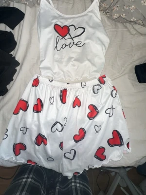 Vit pyjamas med hjärtmönster - Pyjamas sett som aldrig är använt, den har lite päls på sig men ja kommer att tvätta och rulla dem innan ja skickar iväg, hund o katt finns i hemmet💗