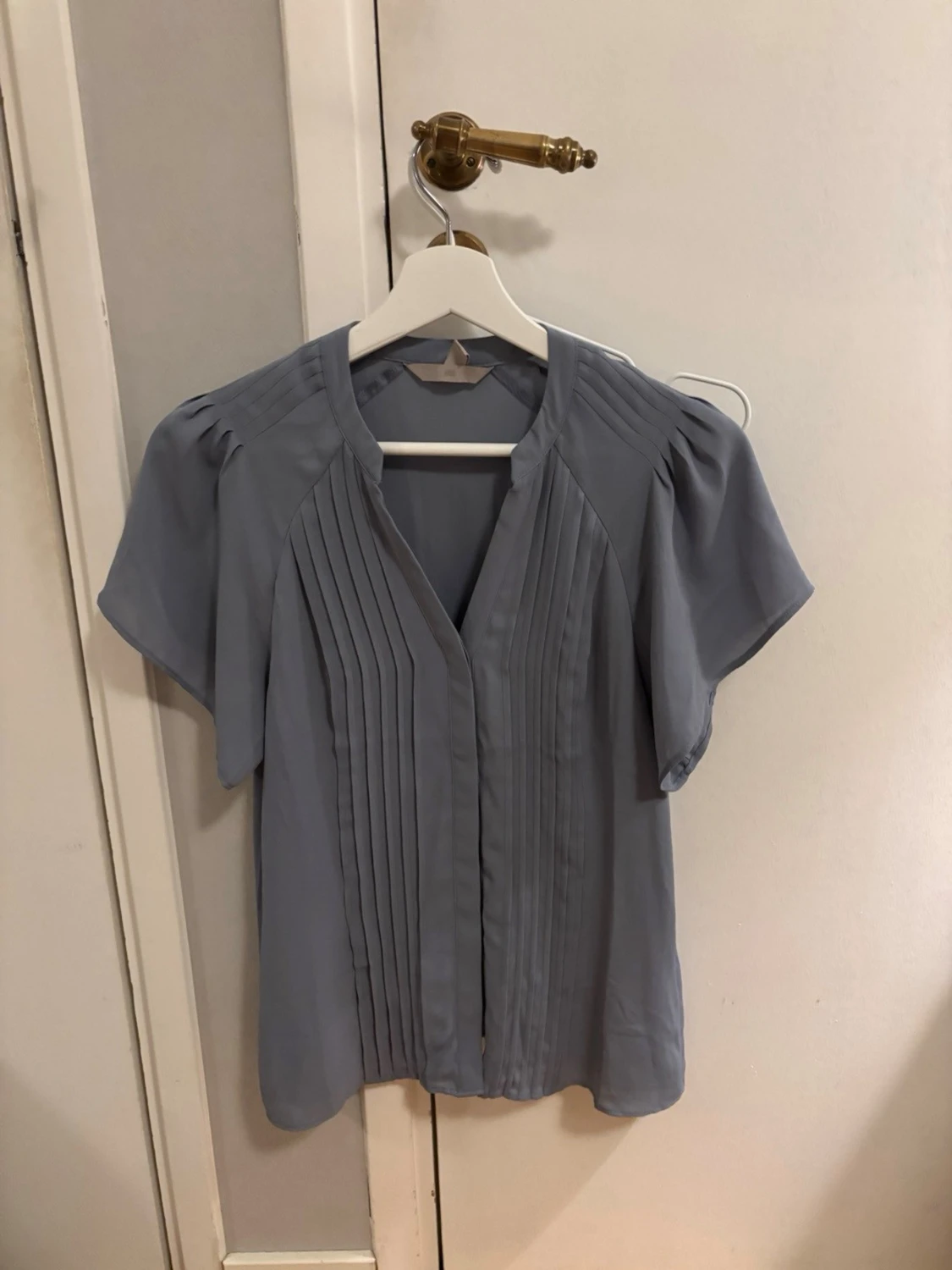 Ljusblå blus med veckad front