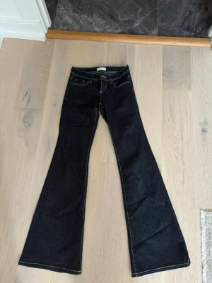 Mörkblå bootcut jeans - Säljer ett par superfina mörkblå bootcut jeans med vita kontrastsömmar. Använda en gång 🌸