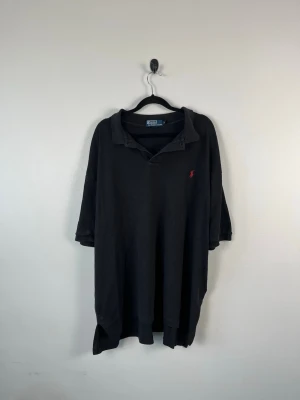Vintage Polo Ralph Lauren Piké XL Svart Röd Pony 100% Bomull Herr - • Storlek: XL • Färg: Svart • Passform: Classic Fit  • Krage: Klassisk pikékrage • Material: 100% bomull  Skick: Plagget är i väldigt fint skick. Eventuella anmärkningar anges alltid tydligt i beskrivningen och visas på bilderna.  Nypris: Cirka 1 500 kr.  📦 Skickas snabbt och packas omsorgsfullt. 💬 Hör gärna av dig om du har frågor eller vill se fler bilder. 🤝 Samfrakt erbjuds vid köp av flera plagg – kika gärna in mina andra annonser!