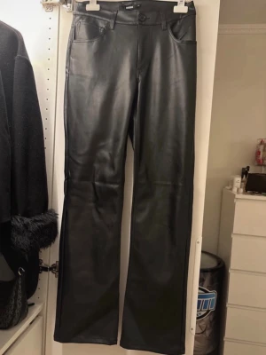 Svarta skinnbyxor - Säljer ett par helt nya skinnbyxor från bikbok i storlek 38 då dom är för långa på mig. De är straight och beskrivs vara low waist men skulle säga att dom är mer mid waist.