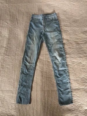 Ljusblå jeans från H&M Divided - Säljer ett par ljusblå jeans från H&M Divided. Jeansen har hög midja, tillverkade i stretchigt denimtyg för en bekväm passform. Perfekta till en avslappnad och trendig look.