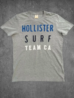 Vintage Hollister T-Shirt - Grå - Vintage Hollister T-Shirt - Grå  Storlek: S Skick: Mycket bra Hör gärna av dig om du har några frågor, vill ha mått eller fler bilder! Finns en liknande T-shirt på profilen. Paketpris vid köp av båda!