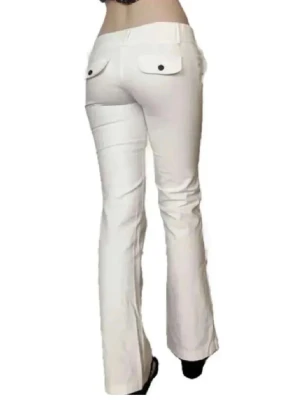 Vita bootcut byxor med fickdetaljer - Snygga vita jeans/byxor med bootcut passform och låg midja. Byxorna har två fickor med lock och knapp bak samt klassisk knappgylf framtill. Perfekta för en trendig och fräsch look.