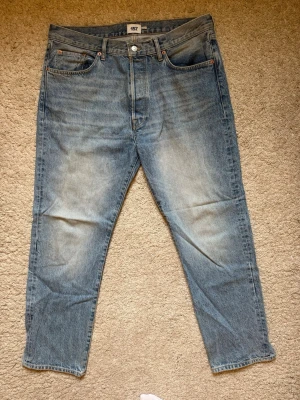 Ljusblå relaxed straight jeans - Säljer ett par ljusblå jeans från 157 med rak passform och klassisk femficksdesign. Jeansen har en snygg tvättad look och är tillverkade i denim med tydliga sömmar och bälteshällor. Perfekta för en avslappnad stil. Endast använda ett fåtal gånger, så fint skick!