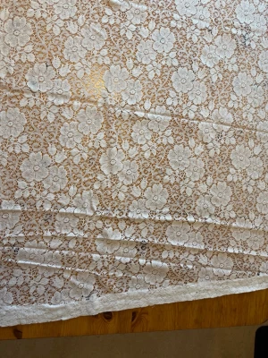 Vita spetsgardiner med blommönster - Säljer två rektangulära vita spetsgardiner med detaljerat blommönster. Gardinerna är tillverkade i tunt, genombrutet tyg och har en klassisk, romantisk känsla. Måtten är 240 centimeter långa och 105cm breda.