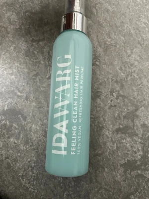 IDAWARG Feeling Clean Hair Mist - Fräsch hårmist från IDAWARG i en ljusblå plastflaska med silvrig spraypump. Produkten är 100% vegansk och fungerar som en uppfriskande hårparfym. Perfekt för att snabbt fräscha upp håret under dagen.
