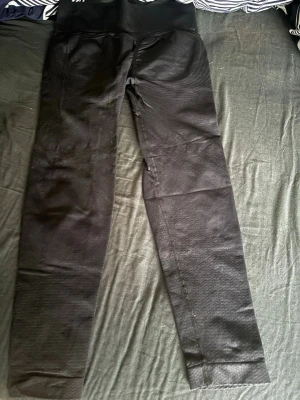 Svarta&marinblåa seamless leggings med hög midja - Säljer ett par svarta seamless leggings med hög ribbad midja och diskret mönster längs benen. Stretchigt material som sitter tight och formar sig efter kroppen. Perfekta för träning eller chill dagar. Samt ett par marinblåa exakt lika dom svarta. Varförsig kostar dom 125kr. 