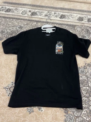 Svart Casa Blanca t-shirt med tryck - Snygg svart t-shirt från Casa Blanca med färgglatt tryck fram och stort motiv på ryggen. Pris kan diskuteras 