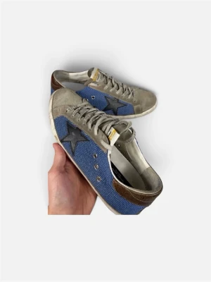 Blå och grå golden goose  - Snygga sneakers i blått tyg med grå mockadetaljer och svart stjärna på sidan. Skorna har vita sulor, bruna detaljer vid hälen och grå snörning. Perfekta för dig som gillar en avslappnad och trendig stil.