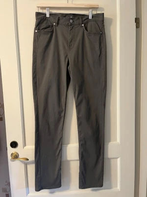Mörkgråa raka byxor från H&M strl 29/32 - Mörkgråa byxor från H&M med rak passform och klassisk femficksdesign. Slim fit. Material 98% bomull, 2% elastan. Storlek 29/32.
