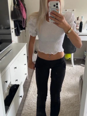 Vit croppad topp med puffärmar - Säljer en vit croppad topp med puffiga kortärmar och smockad kropp. Toppen har volangkant nedtill och är perfekt för dig som gillar trendiga detaljer och en feminin look. Materialet känns lätt och luftigt, perfekt för varmare dagar. Ifrån hm 🤗