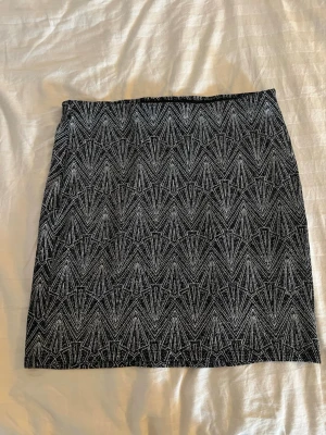 Svart kjol med glitter detaljer - Kort kjol från H&M Divided i svart med glittriga detaljer. Kjolen har rak passform och resår i midjan. Perfekt för nyår eller fest