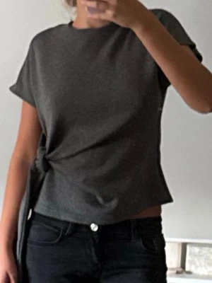 Mörkgrå knyt topp Zara - Jättesnygg mörkgrå stickad T-shirt från Zara med knyte på sidan