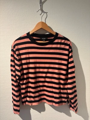 Randig långärmad  - Randig långärmad tröja från Monki i svart och rosa/aprikos🖤🩷 Storlek XS