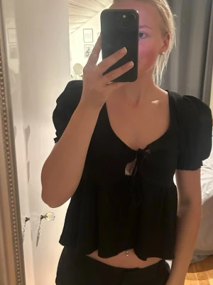Svart blus med puffärmar och knyt - Trendig svart blus med puffärmar och knyt framtill. Från Gina tricot i strl S, använd endast en gång. Nypris 279