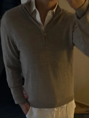 Oscar Jacobson half zip - Snygg half zip från Oscar Jacobson. Långärmad modell med ribbade muddar vid ärmslut och nederkant. Perfekt att bära över en skjorta för en clean look.