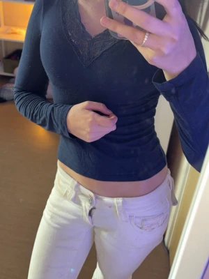 Mörkblå långärmad topp med spets - Mörkblå långärmad topp från Gina Tricot med v-ringning och dekorativ spetsdetalj vid halsen. 