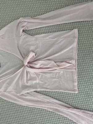 Ljusrosa omlottopp från Gina Tricot - Supersöt ljusrosa omlottopp från Gina Tricot med långa ärmar och knyt framtill. Tunn och mjuk i materialet🩷säljer då den var lite för stor i bysten för mig