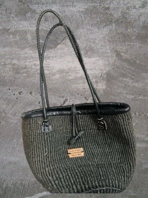 Handvävd mörkgrön sisal handväska - Snygg handväska i svart sisal med dubbla handtag och detaljer i svart läderimitation. Väskan är handvävd i Kenya av sisalfibrer och har en enkel, stilren design med en liten skylt framtill. Perfekt för dig som gillar unika accessoarer. 