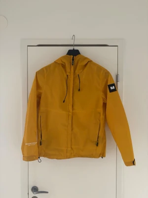 Weekend Offender - Säljer denna gula vind jacka ifrån Weekend Offender | Storlek XS | Har dessvärre en fläck på vänstra armen