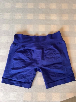 Blå shorts från Relode - Snygga blå shorts från Relode med ribbad linning. Perfekta för träning med stretchigt material som ger en tight och bekväm passform. Diskret logga bak och scrunch-detalj för extra form.