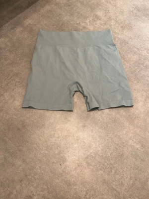 Grön gråa träningsshorts-Hm - Grön gråa träningshorts från hm märket ”move”.  Storlek 158/164. Säljer då de inte passade mig. Helt oanvända och i bra skick.