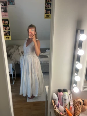 Vit långklänning med v-ringning - Superfin vit långklänning med v-ringad hals och ärmlös design. Nyskick knappt använd! Perfekt lång på mig jag är 166 ungefär! 