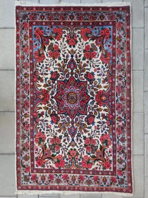 Persisk Handknuten Matta (Bidjar) 96x152 cm - En väldigt fin handknuten persisk matta från staden Bidjar i nordvästra Iran. Väldigt tät, stabil och uthållig. Denna matta har fantastiska färger och ett exklusivt blommönster. Mattan är utrustad med skinnförstärkta sidor men skinnet har några få sprickor. Naturligt åldersrelaterat slitage förekommer, två små fläckar men inte så synligt. Se sista 2 bilderna för slitaget. Om du önskar att mattan tvättas hos professionell matt tvätt så kan jag ordna det. Hör av dig om du undrar något.