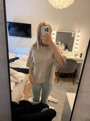 Beige stickad tröja - Säljer en beige stickad tröja med halvlånga ärmar och rund hals. Tröjan har en avslappnad passform och är perfekt att matcha med jeans för en chill look. Materialet känns mjukt och bekvämt mot huden.