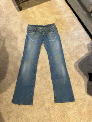 Blå raka lågmidjade jeans från only - Snygga blå raka lågmidjade jeans med bakfickor som har dekorativa fickor. Storlek 38