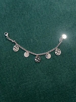 Silverfärgat armband med berlocker - Snyggt silverfärgat armband med fem runda berlocker, varav några har ett utstansat mönster.
