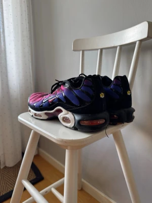 Nike Air Max Plus rosa och lila - Säljer ett par Nike Air Max Plus sneakers i en grym färgkombination av rosa, lila och svart. Skorna har den klassiska vågdesignen, svarta snören och vit sula med synliga Air-enheter. Perfekta för dig som vill sticka ut med dina sneakers. Jag har använt dem 10 gånger så dem är i väldigt bra skick.